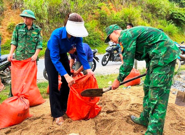 Thanh niên tình nguyện cùng Bộ đội Biên phòng xúc, vận chuyển vật liệu phục vụ chỉnh trang trường học.