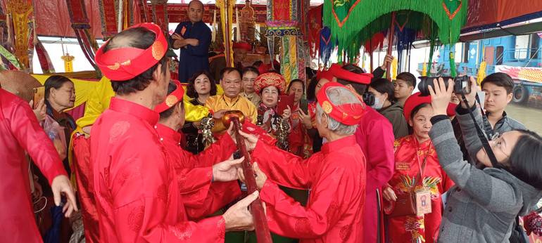 Nước được các cụ bô lão cao tuổi rót vào hai chiếc bình lớn.