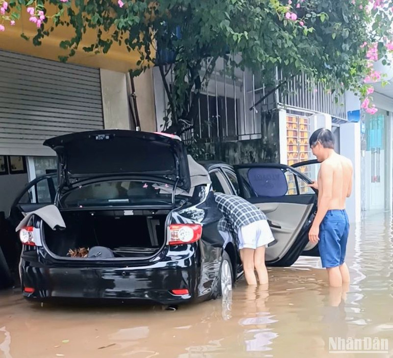 Nước ngập vào trong phương tiện ô-tô của người dân. (Ảnh: Mai Tú)