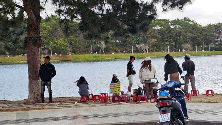 Tình trạng buôn bán tự phát vẫn diễn ra bên hồ Xuân Hương bất chấp quy định. (Ảnh chụp lúc 16 giờ 20 phút ngày 19/2/2025).