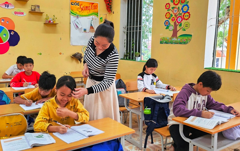 Cô giáo chăm sóc, hướng dẫn học sinh học tập.