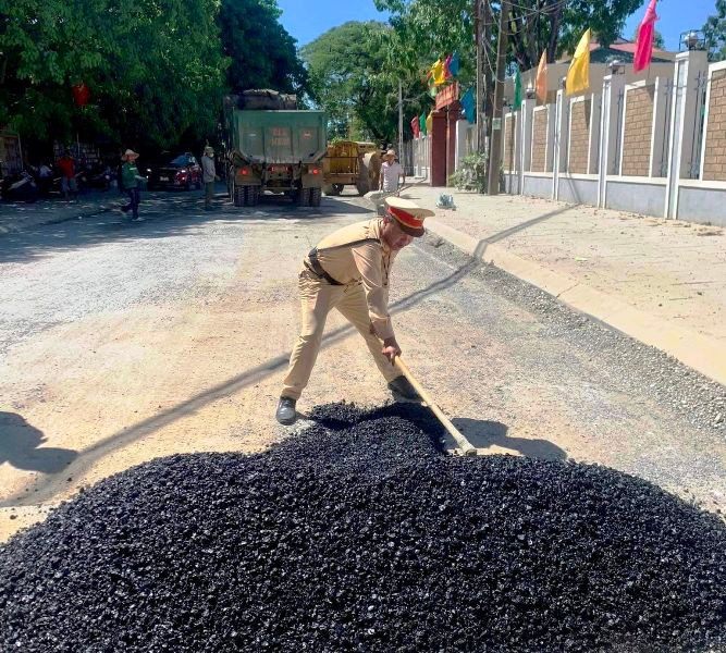 Cảnh sát giao thông tham gia hỗ trợ san bê-tông nhựa, xử lý điểm đường xuống cấp.