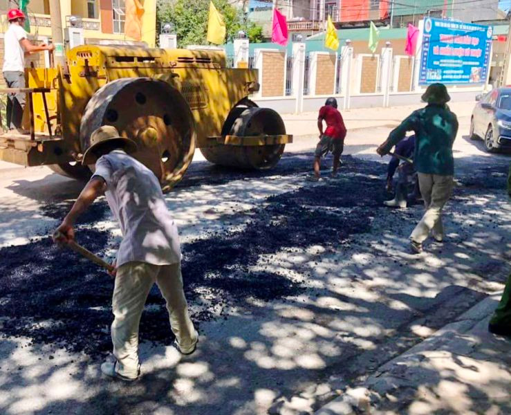 Người dân cùng phương tiện của tập thể, cá nhân tham gia thi công duy tu đường.