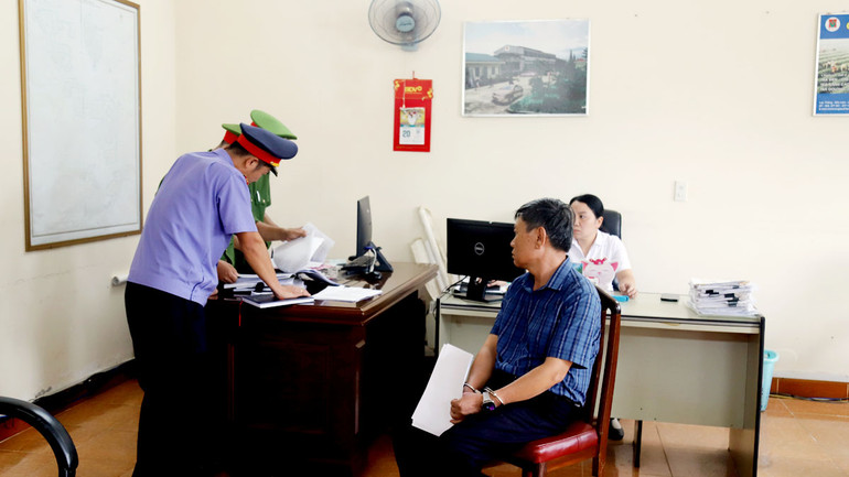 Cơ quan chức năng khám xét nơi làm việc của ông Nguyễn Hữu Giảng. (Ảnh: H.Đ)