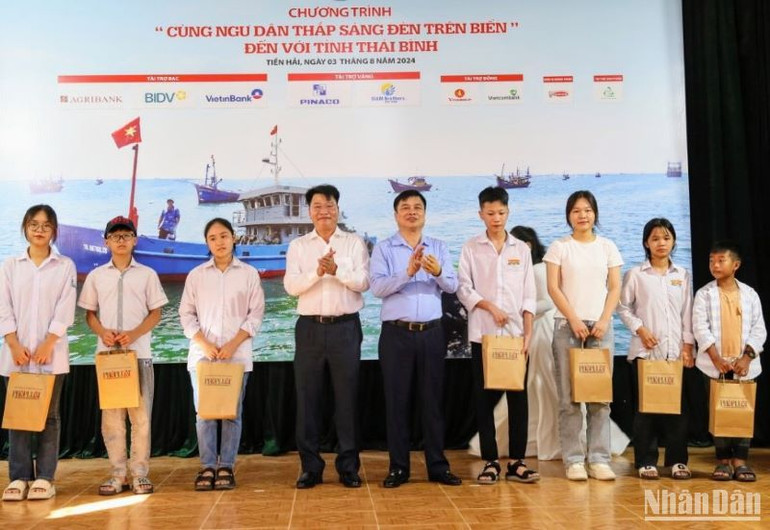 Ban tổ chức trao học bổng cùng đồ dùng học tập cho con em ngư dân hiếu học.