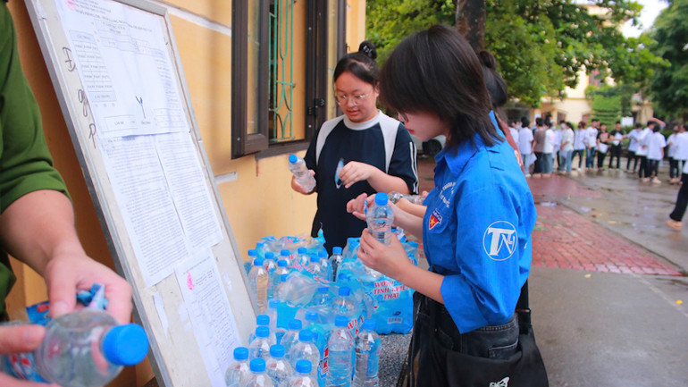 Đội thanh niên tình nguyện chuẩn bị nước uống tặng cho thí sinh. (Ảnh: QUANG HUY)