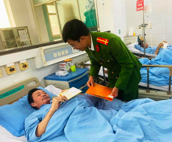 Thành viên đoàn công tác trao quà tặng tới bệnh nhân đang điều trị nội trú.