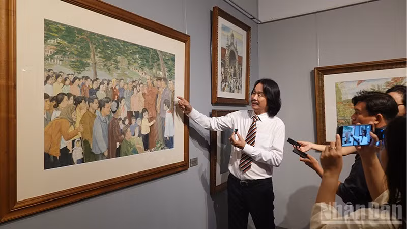 Họa sĩ Văn Đức, con trai họa sĩ Văn Giáo giới thiệu với công chúng bức tranh Bác Hồ thăm nhân dân Hà Bắc (1978). (Ảnh: LINH BẢO)