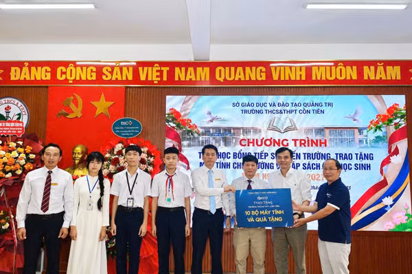 Đại diện Công ty Cổ phần Kaopiz Holdings và Báo Nhân Dân trao tặng máy tính cho Trường trung học cơ sở và trung học phổ thông Cồn Tiên. (Ảnh: Lâm Quang Huy)