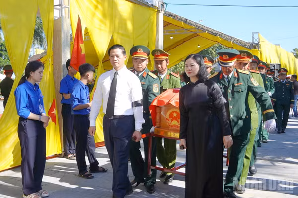 Các đại biểu tiễn đưa các liệt sĩ về nơi an nghỉ. (Ảnh: H.M)