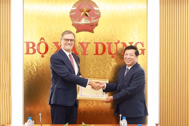 Bộ trưởng Trần Hồng Minh trao tặng Kỷ niệm chương Vì sự nghiệp Xây dựng cho Đại sứ đặc mệnh toàn quyền Cộng hòa Pháp tại Việt Nam Olivier Brochet. (Ảnh: Cổng thông tin điện tử Bộ Xây dựng)