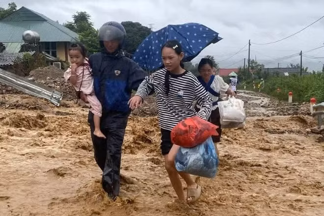 Người dân xã Mường Than di chuyển trên Quốc lộ 32 tới nơi an toàn. (Ảnh: Báo Nhân Dân)