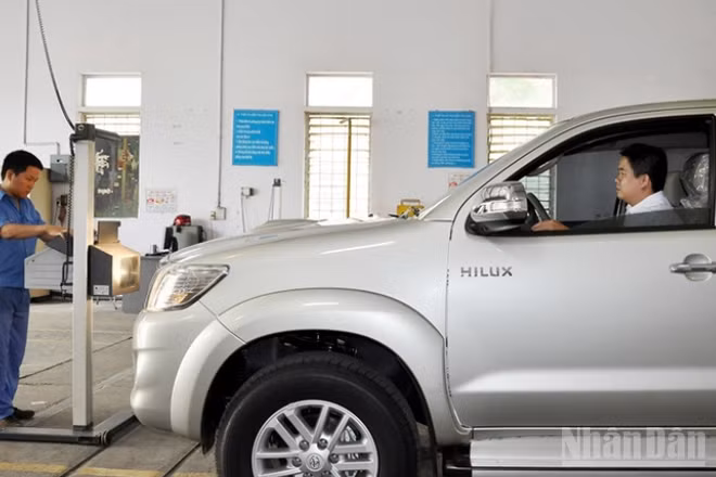 Đăng kiểm viên thực hiện đăng kiểm với một xe ô-tô.