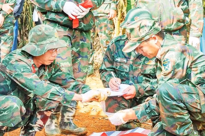 Lực lượng chức năng cẩn trọng, tỉ mỉ và giữ gìn sự tôn nghiêm trong quá trình cất bốc hài cốt liệt sĩ.