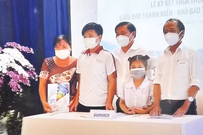 Đại diện Chương trình “Cùng con đi tiếp cuộc đời” trao suất bảo trợ cho em Lê Thị Ngọc Tuyết và em Lê Minh Khang có cha mất trong đại dịch Covid-19 (Ảnh BÁO THANH NIÊN)