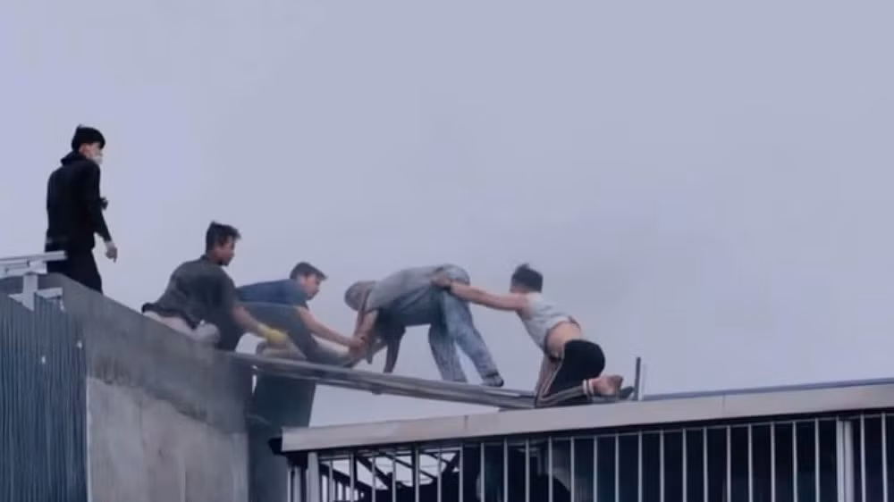 Người dân dũng cảm dùng búa phá mái nhà cứu người thoát nạn trong vụ cháy tại phường Hoàng Mai (Hà Nội). (Ảnh: HÀ NHUNG)