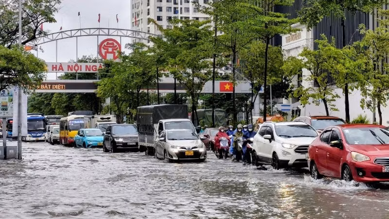 Ngập sâu tại Quốc lộ 32 khiến việc di chuyển của người dân gặp nhiều khó khăn. (Ảnh: VĂN THỊNH)