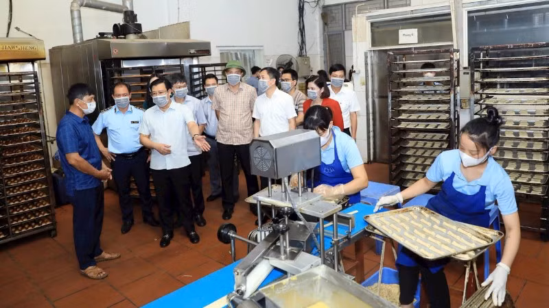 Đoàn khảo sát của Thường trực HĐND thành phố Hà Nội kiểm tra việc chấp hành các quy định của pháp luật về an toàn thực phẩm tại một cơ sở sản xuất bánh kẹo ở xã An Khánh. (Ảnh: LÊ HẢI)