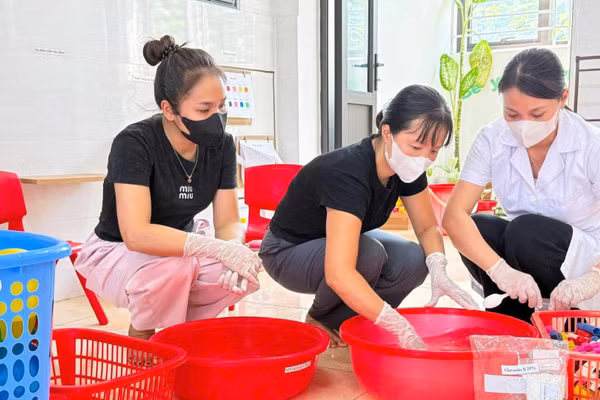 Cán bộ y tế, giáo viên Trường mầm non Tân Ước (xã Dân Hòa, Thành phố Hà Nội) thực hiện vệ sinh đồ chơi trước khi đón trẻ trên địa bàn bước vào năm học mới 2026-2027. Ảnh: VÂN SƠN