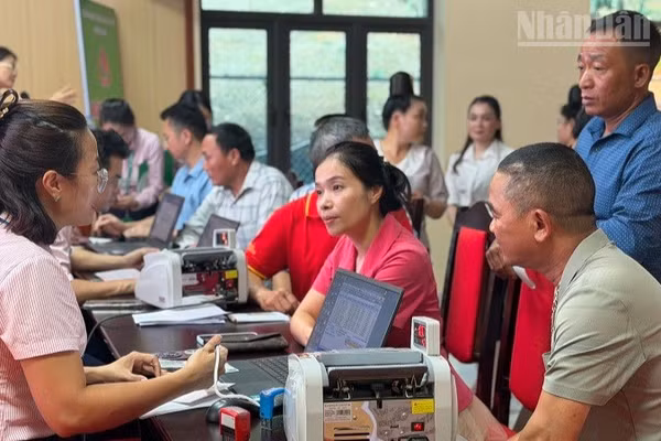 Cán bộ, nhân dân xã Búng Lao tham gia mở sổ tiết kiệm theo lời kêu gọi từ Phòng Giao dịch Ngân hàng Chính sách-xã hội Mường Ảng, tỉnh Điện Biên. (Ảnh: LÊ LAN)