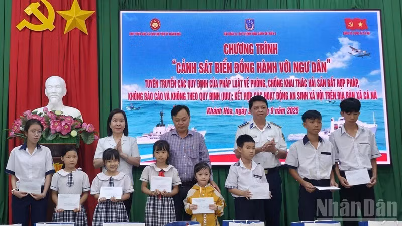 Lãnh đạo Ban Tuyên giáo và Dân vận Tỉnh ủy Khánh Hòa và đại diện lãnh đạo Hải đoàn 32, Bộ Tư lệnh Vùng Cảnh sát biển 3 tặng quà cho học sinh là con ngư dân xã Cà Ná. (Ảnh: NGUYỄN TRUNG)