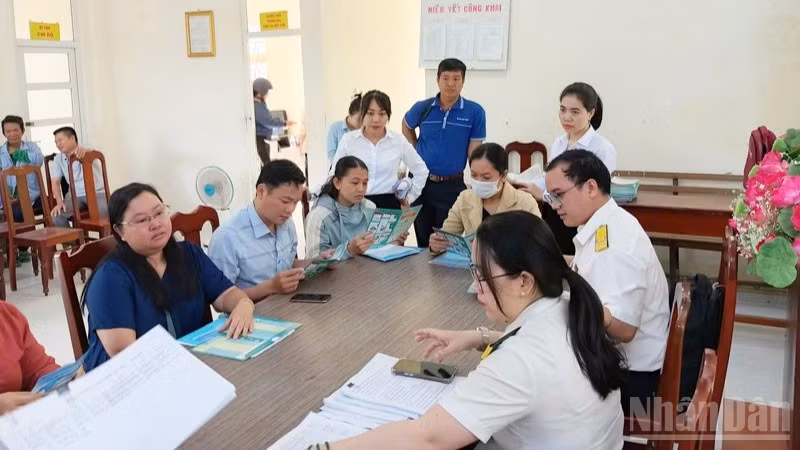Cán bộ thuế tỉnh Khánh Hòa tuyên truyền, hướng dẫn các hộ kinh doanh tìm hiểu những quy định về quyền lợi, nghĩa vụ theo Nghị định 141/2026/NĐ-CP vừa được Chính phủ ban hành ngày 29/4/2026. (Ảnh: đơn vị cung cấp)