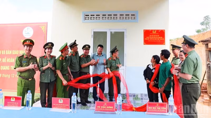 Lãnh đạo Công an tỉnh Khánh Hòa cùng gia đình chị Cao Thị Muỗi thực hiện nghi thức khánh thành và bàn giao căn nhà. (Ảnh: N.T)