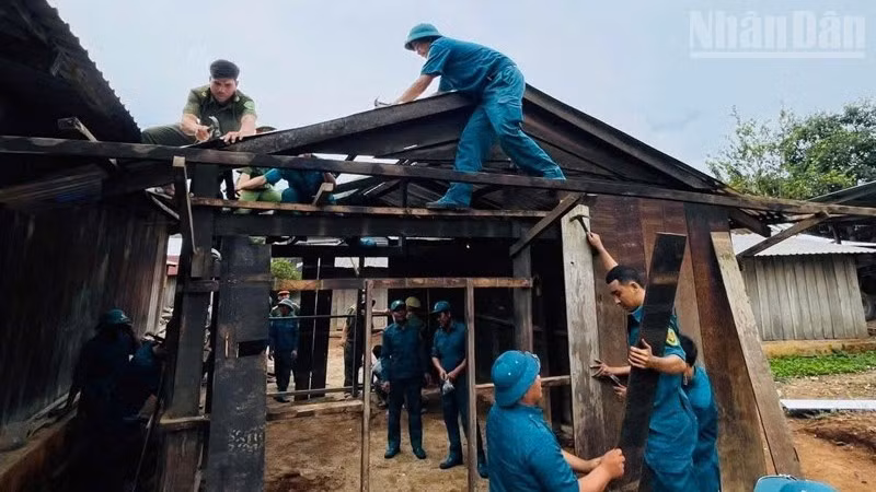 Hình ảnh người lính quân hàm xanh cùng dân quân địa phương miệt mài dưới nắng gió, để hoàn thiện nhà ở cho các gia đình thuộc diện con đẻ của người hoạt động kháng chiến bị nhiễm chất độc hóa học đã trở thành biểu tượng đẹp của tinh thần trách nhiệm, nghĩa tình quân-dân. (Ảnh: HUY VIÊN)