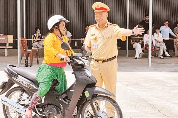 Cán bộ Đội Sát hạch cấp giấy phép lái xe cơ giới đường bộ, Phòng Cảnh sát giao thông, Công an tỉnh Tuyên Quang hướng dẫn người dân thi sát hạch giấy phép lái xe mô-tô.