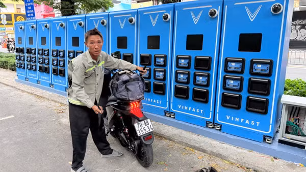 Người sử dụng xe máy điện sử dụng tủ đổi pin. (Ảnh: VÕ LÊ)