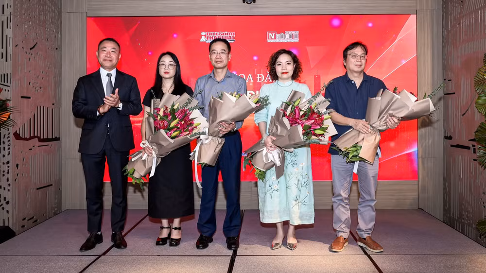 Ông Phạm Quốc Huy - Tổng Biên tập Tạp chí Đời sống và Pháp luật tặng hoa cho các diễn giả tại tọa đàm. (Ảnh: TRỌNG TÙNG)