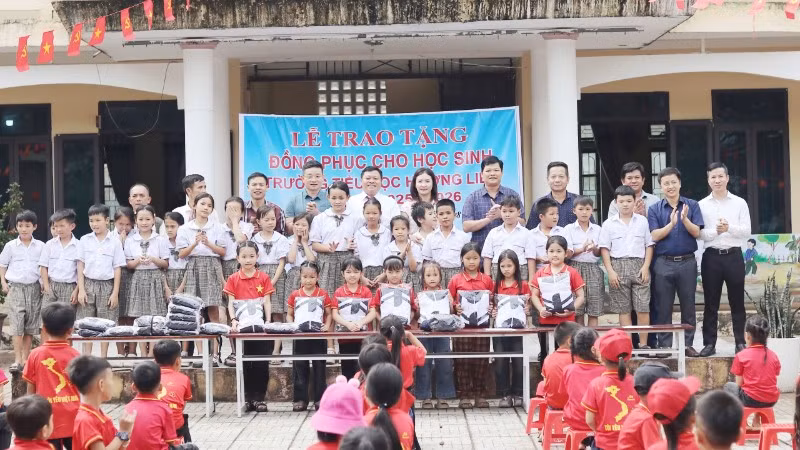 Đại diện Văn phòng Báo Nhân Dân tại Hà Tĩnh cùng lãnh đạo cấp uỷ, chính quyền địa phương và nhà tài trợ trao tặng gần 500 áo đồng phục cho học sinh Trường tiểu học Hương Liên.