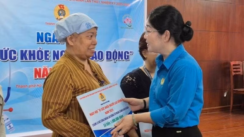 Bà Nguyễn Kim Loan, Phó Chủ tịch Liên đoàn Lao động Thành phố Hồ Chí Minh tặng quà cho lao động nữ bị bệnh hiểm nghèo. (Ảnh: Mai Chi) 