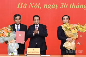 Thủ tướng Chính phủ Phạm Minh Chính trao Quyết định bổ nhiệm và tặng hoa chúc mừng hai đồng chí Trần Đức Thắng và Hồ Văn Niên. (Ảnh: TRẦN HẢI)