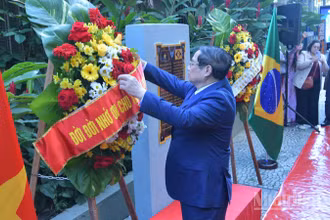 Thủ tướng Chính phủ Phạm Minh Chính chỉnh hoa chuẩn bị thực hiện nghi thức dâng hoa tưởng niệm Chủ tịch Hồ Chí Minh tại Rio de Janeiro (Ảnh: Thanh Giang).