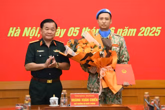 Thượng tướng Hoàng Xuân Chiến tặng hoa chúc mừng, động viên Thiếu tá Trần Viết Cường lên đường làm nhiệm vụ.