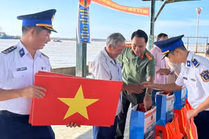 Lực lượng chức năng trao cờ, tặng quà cho ngư dân tỉnh Lâm Đồng. (ẢNH: KIỀU KIỀU)