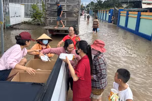 Các nhóm tình nguyện phát cơm giữa dòng lũ.
