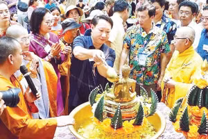 Các sư thầy và đại biểu thực hiện nghi thức tắm Phật.
