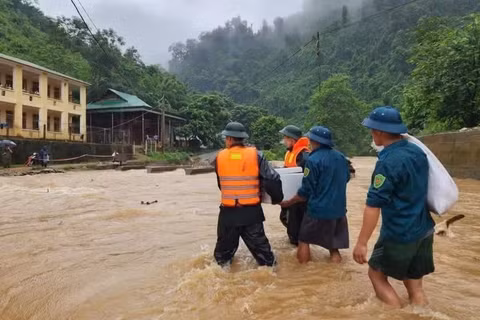 Cán bộ, chiến sĩ Đồn Biên phòng Tam Hợp và Ban Chỉ huy quân sự xã Tam Thái, tỉnh Nghệ An, đưa cơm cho học sinh điểm trường bán trú bị mưa lũ chia cắt. (Ảnh: TRUNG HIẾU) 