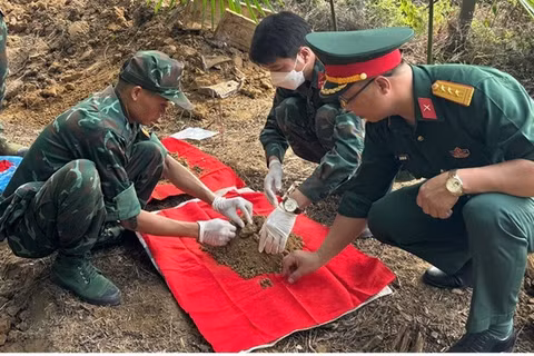 Lực lượng chức năng tiến hành khai quật, cất bốc các hài cốt liệt sĩ. (Ảnh: THANH SƠN)