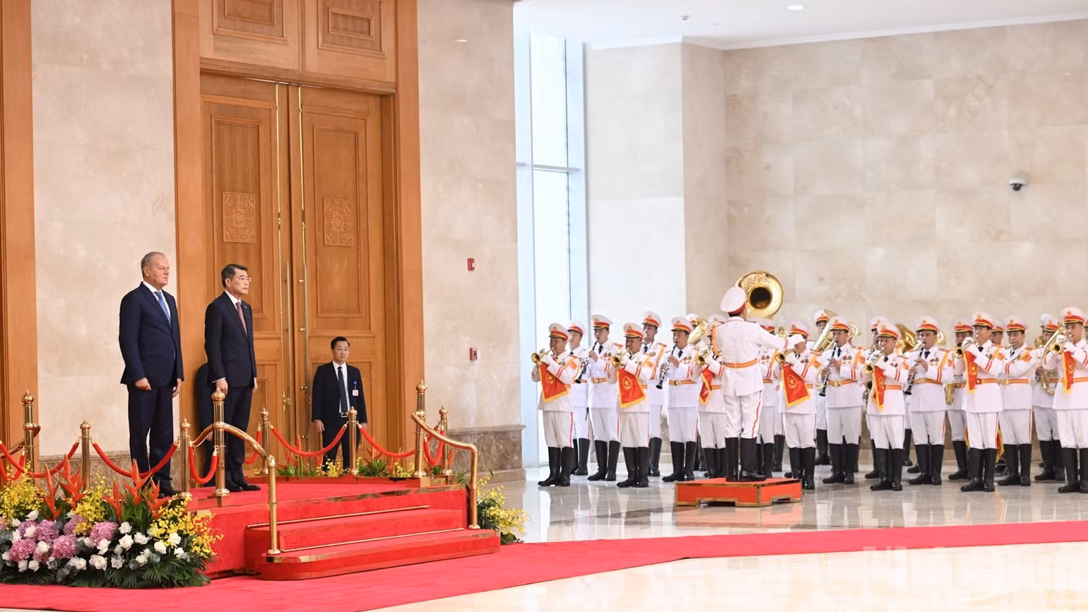 Thủ tướng Lê Minh Hưng và Thủ tướng Donald Tusk đứng trên bục danh dự nghe cử hành Quốc thiều Việt Nam và Ba Lan tại lễ đón chính thức. (Ảnh: TRẦN HẢI)