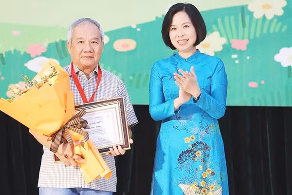 Tổng Giám đốc TTXVN Vũ Việt Trang trao giải Hiệp sĩ Dế Mèn cho nhà văn Trần Đức Tiến. Ảnh: MINH ANH