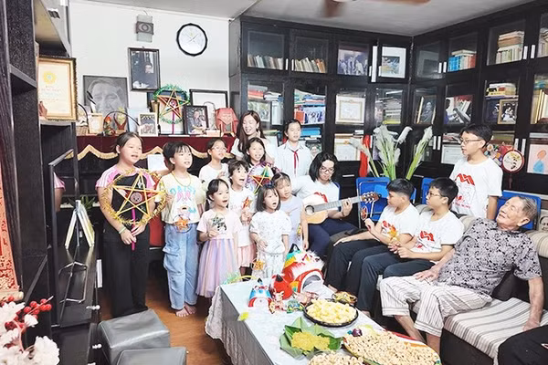 Các em nhỏ hát bài ca "Chiếc đèn ông sao" trong căn phòng của gia đình tác giả.
