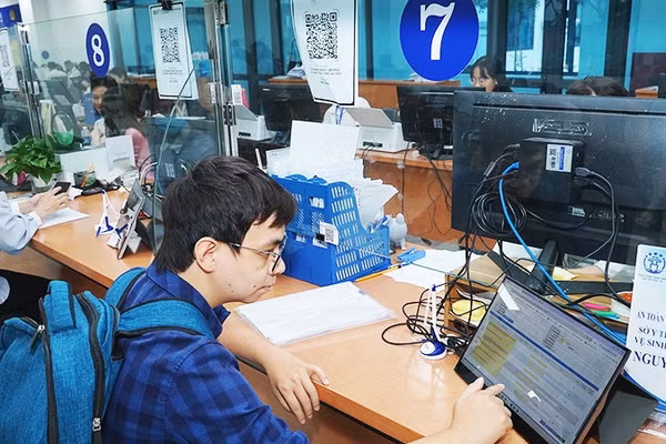 Người dân làm thủ tục tại trung tâm phục vụ hành chính công. Ảnh: NAM HẢI