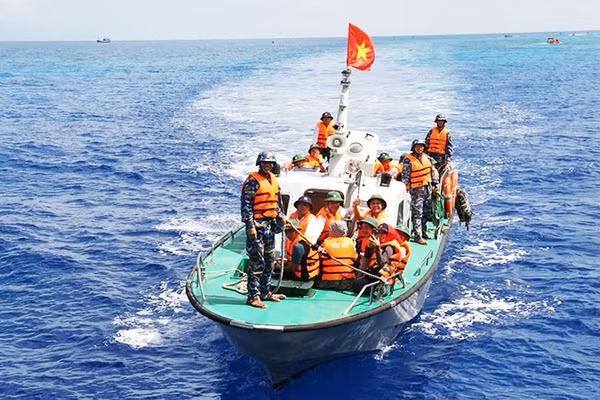 Ca-nô chở đại biểu Đoàn công tác số 19 từ tàu KN 491 vào đảo. Ảnh: THÁI THUẦN