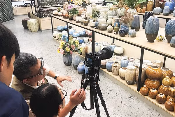 Nghệ sĩ nhiếp ảnh Lê Bích bồi dưỡng cho nhân viên Bảo tàng gốm Bát Tràng kỹ năng chụp ảnh quảng bá sản phẩm của làng nghề. Ảnh: HOÀNG HOA