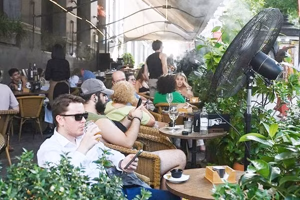 Du khách tránh nắng trong quán cà-phê phun sương tại Madrid, Tây Ban Nha. Ảnh: XINHUA