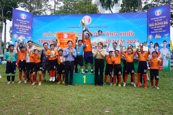 Anh Sanh (người nâng cúp) khoe cúp vô địch cùng các cầu thủ trẻ tại một giải đấu. Ảnh: NVCC