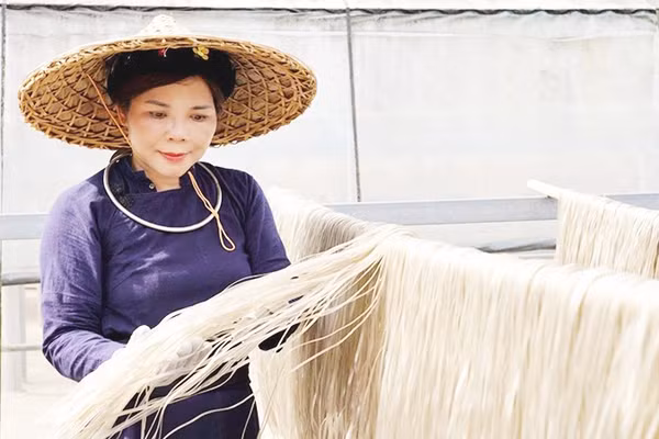 Chị Hoan kiểm tra miến phơi khô tự nhiên dưới nắng. 
